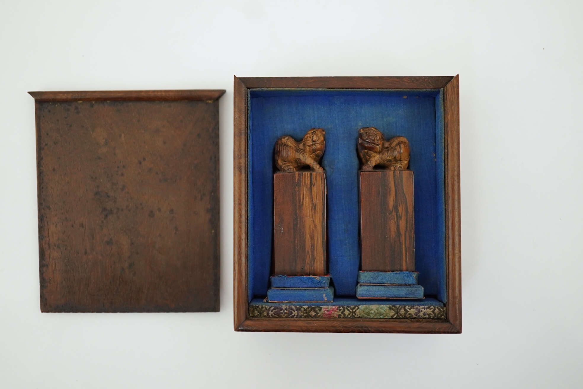 A cased pair of Chinese hardwood ‘lion-dog’ seals, early 20th century